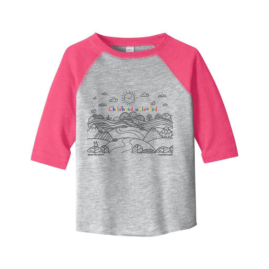 Child's line drawing of mountain range with "Childhood unlocked" written in primary colors. Cotton raglan jersey baseball tee. Toddler t-shirt with 3/4 sleeves. Heather gray shirt with pink sleeves and collar.